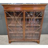 A late 19th century mahogany astragal glazed two door bookcase with three adjustable shelves, raised