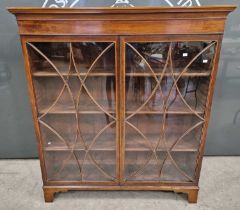 A late 19th century mahogany astragal glazed two door bookcase with three adjustable shelves, raised