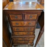 A reproduction mahogany chest of drawers in the form a chest on chest, with two short over three