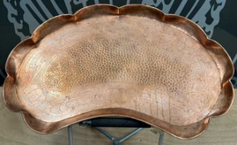 An Art Nouveau style kidney shaped copper tray with hammered detail to centre.