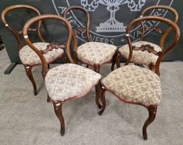 A set of five antique mahogany balloon-back dining chairs with matching floral needlework