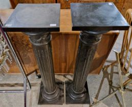 A pair of black composite doric columns, 103cm high.