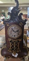 A late 19th / early 20th century Rococo style table clock, the silvered dial with Roman numerals and