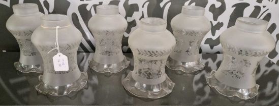 A set of six antique clear and frosted glass hurricane lamp shades with etched floral details.