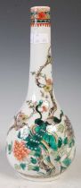 A Chinese porcelain famille verte bottle vase, Qing Dynasty, decorated with two peacocks standing on