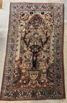 A mid 20th century Persian rug, the rectangular field with Mihrab shaped panel enclosing a tree of