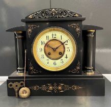 An antique architectural form slate mantle clock with gilded accents, the Arabic numeral dial with