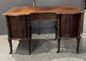 An antique mahogany inverted bowfront kneehole desk/ dressing table with central frieze drawer,