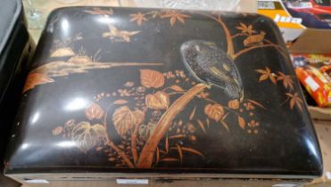 A Japanese lacquer box, late 19th/ early 20th century, decorated with applied bronze bird perching