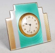 An early 20th century Art Deco style white metal and coloured enamel strut table clock, centred with