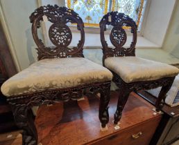 A pair of Colonial carved and pierced wood side chairs, the tops with stylised birds and pierced