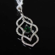 A white metal, emerald and diamond set pendant, centred with a pear-shaped emerald estimated to