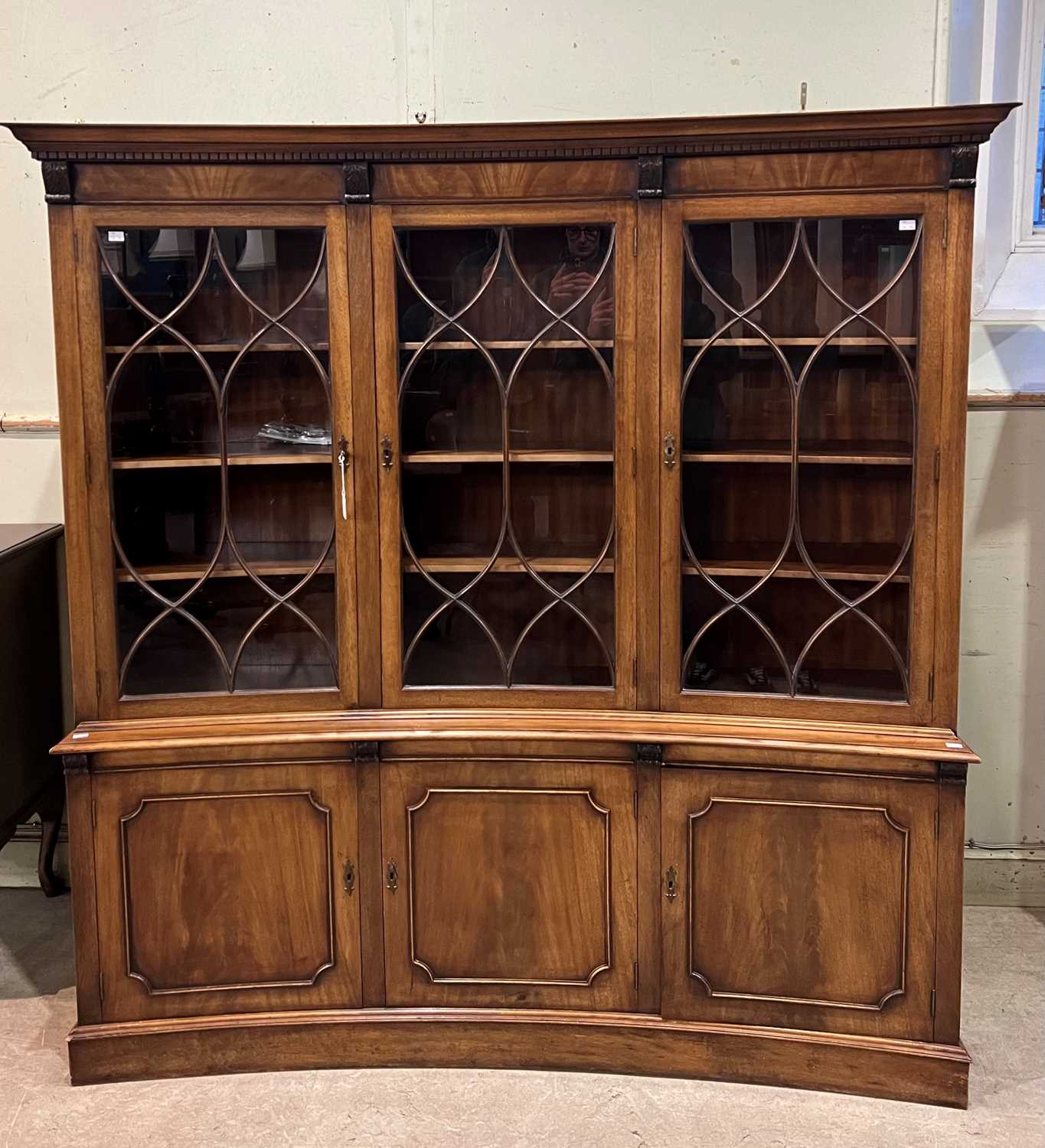 A Georgian style mahogany inverted bow front two-part display cabinet, the upper section with