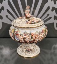 A Capodimonte pedestal bowl and cover, decorated with cherubs, flowers and animals, with gilded