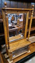 An antique oak vanity cabinet with bevelled mirror glass panel above a serpentine form shelf with