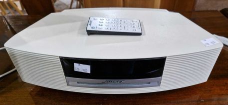 A Bose Wave music system, model AWRCC6, with power cable and remote control.