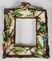 A pottery rectangular photograph frame surround, decorated with birds and foliage, signed 'E. L. S',