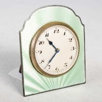 An early 20th century white metal and green enamel strut table clock, the circular dial with