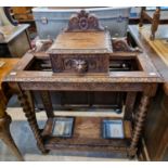A 19th centiury carved oak twin-division hall stand, centred with a hinged storage compartment