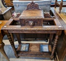 A 19th centiury carved oak twin-division hall stand, centred with a hinged storage compartment