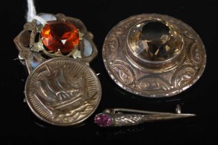 A group of four assorted Scottish silver and white metal brooches to include a circular Iona style