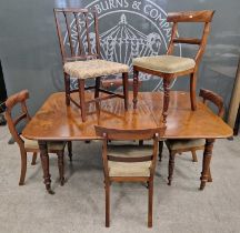 A 19th century mahogany extending dining table with single leaf raised on four turned cylindrical