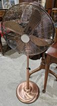 A Dunelm rose gold coloured floor fan.