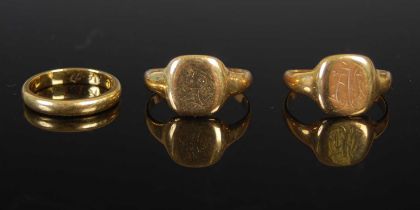 An 18ct gold wedding ring, ring size 'I/J', together with two other 18ct signet rings, gross