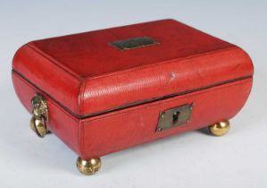 A George III red leather sarcophagus shaped casket, the hinged cover centred with a plaque inscribed