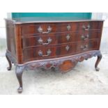 A late George III style mahogany serpentine commode, the shaped rectangular top above three long