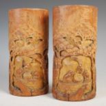 Two Chinese bamboo brush pots, 20th century, carved with figures and trees, 20.5cm high (2).