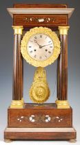 A French Charles X rosewood and brass inlaid Portico clock, the engine turned silvered dial with