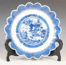 A Chinese porcelain blue and white flower shaped dish, Qing Dynasty, decorated with pavilions in a