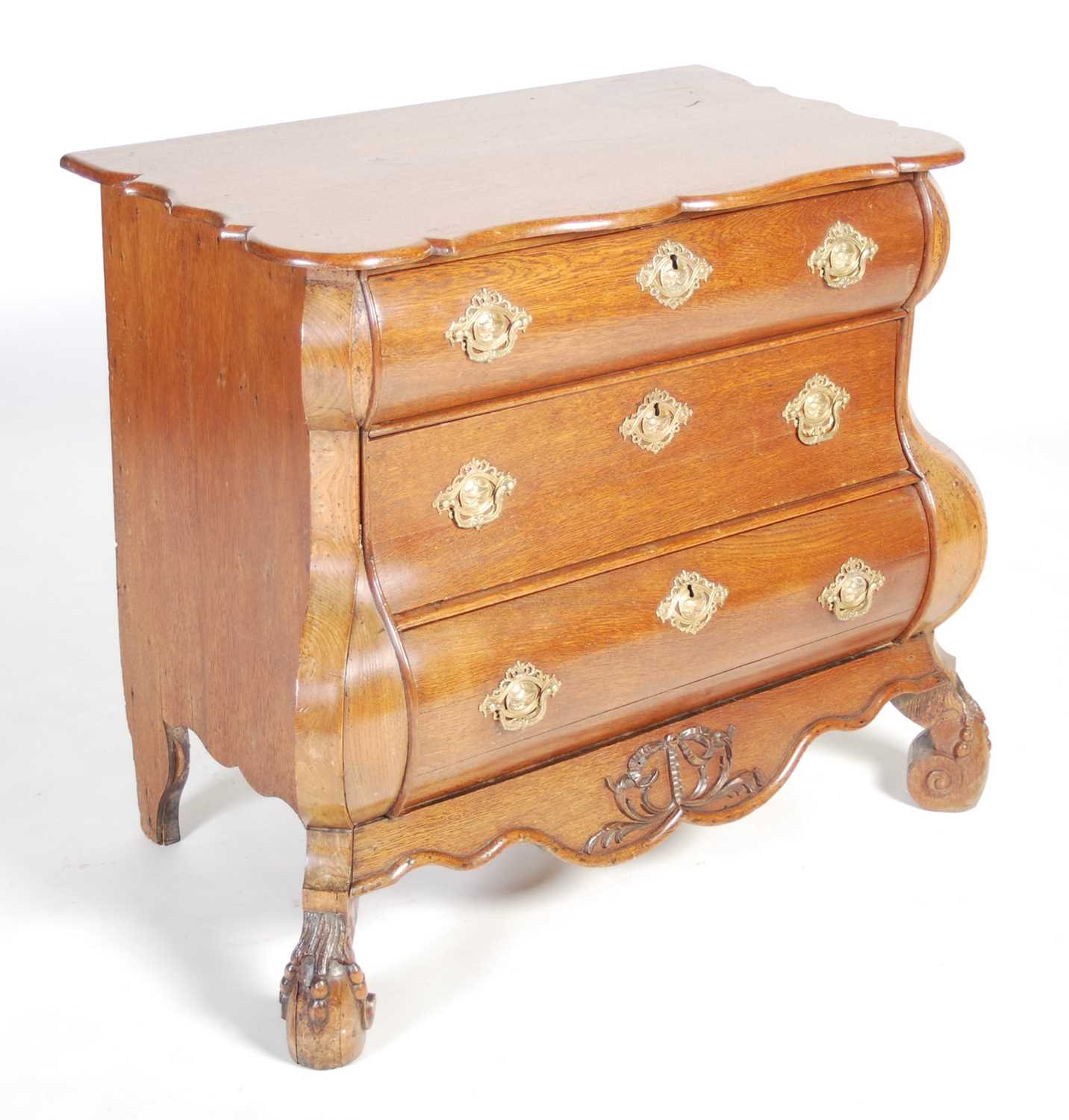 A late 18th century Dutch oak bombe chest, the shaped rectangular top above three long drawers and a