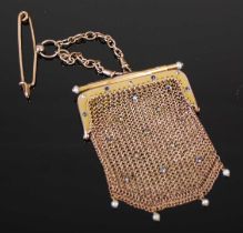 A yellow metal pearl and sapphire studded chainmail purse suspended on a 9ct gold chain, the purse