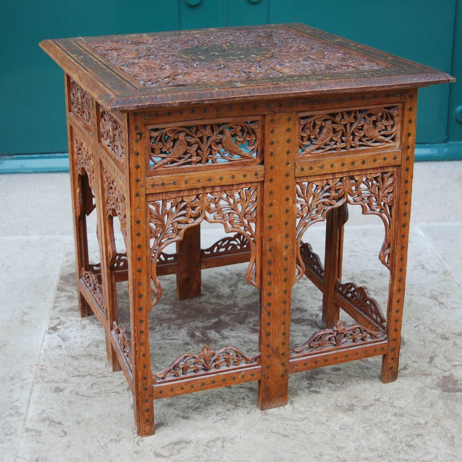 A late 19th / early 20th century Indian carved wood and brass inlaid occasional table, the