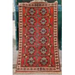 A Persian rug, Ghoochan, the rectangular madder field decorated with two rows of six octagonal