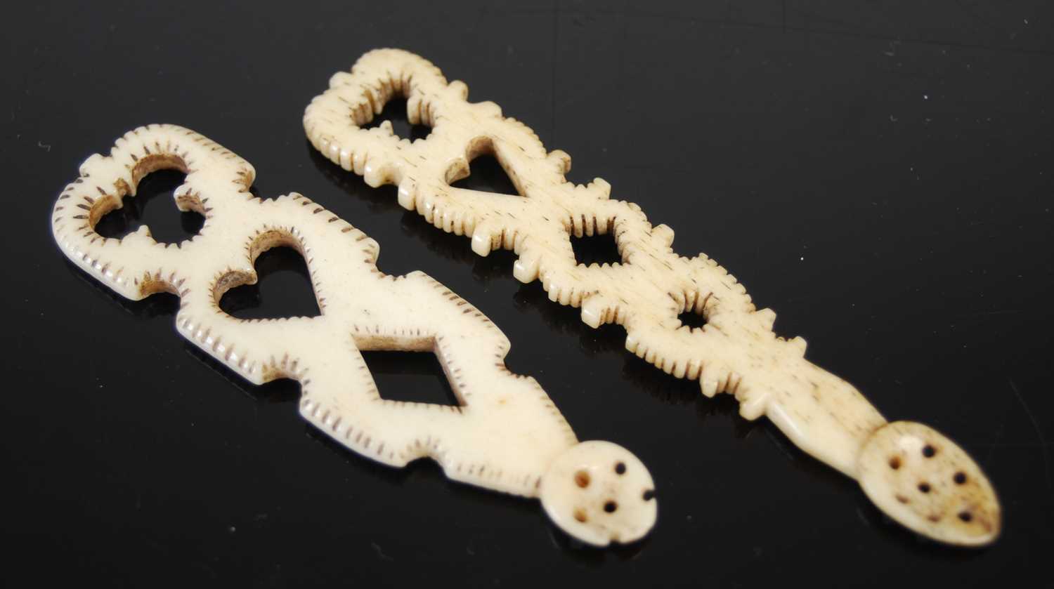 Two Scottish carved bone snuff spoons each formed as a miniature ‘love’ spoon, pierced with heart