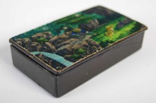 A black lacquer papier-mâché oblong snuff box, the hinged cover painted with a scene depicting