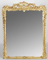 A 19th century carved giltwood over mantel mirror, the frame carved with scrolls, flowers and