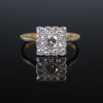 A yellow and white metal diamond cluster ring, set with a central round brilliant cut diamond in a