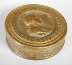 A cast brass circular snuff box, the pull-off cover stamped with a commemorative portrait bust