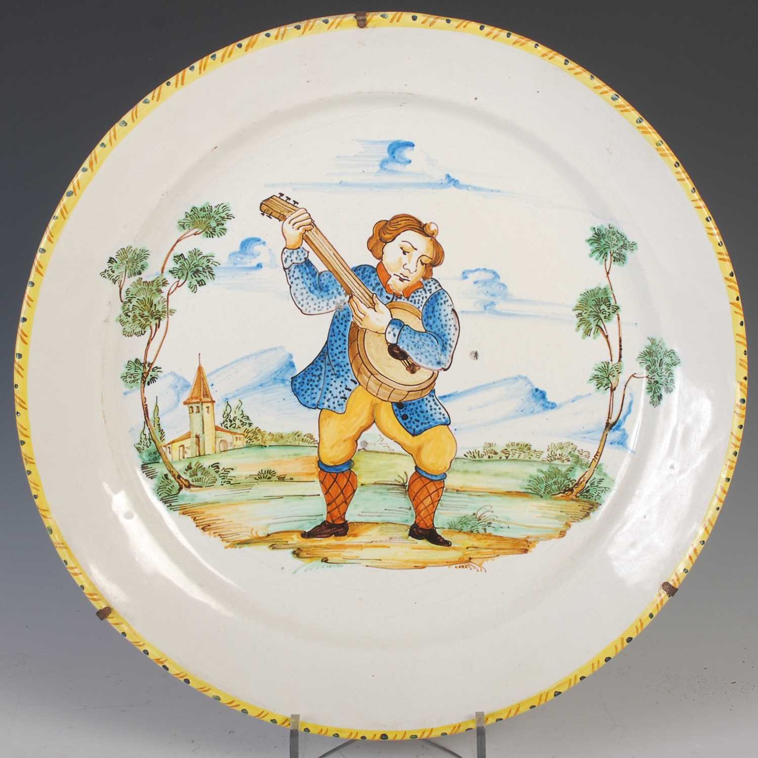 A pair of Italian pottery chargers, late 19th/ early 20th century, decorated with musicians, 38cm