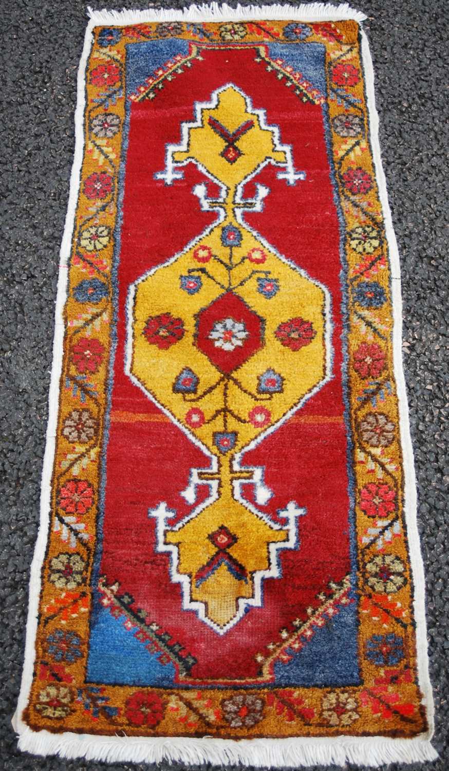 A small Persian rug/ mat, 20th century, the madder ground centred with an ochre-coloured medallion