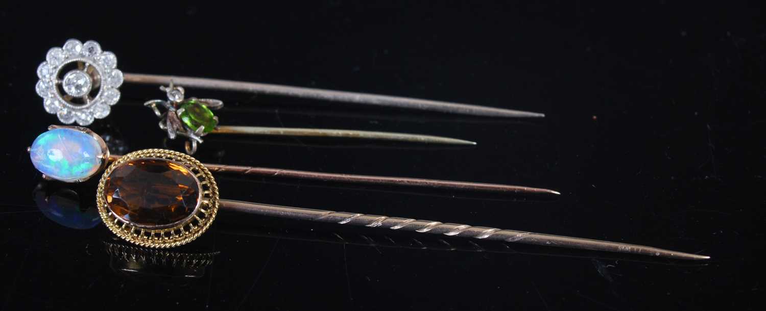 A collection of four late 19th century and later stick pins, comprising; a yellow metal diamond