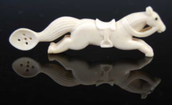 A Scottish bone snuff spoon carved in the form of a galloping horse, with bridle, reins, and