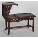 A Chinese dark wood urn stand of asymmetric form, with three various open shelves, pierced dragon,