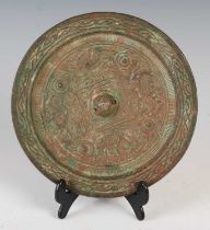 A Chinese bronze mirror, of circular form, cast in relief with four stylised animals, 19cm