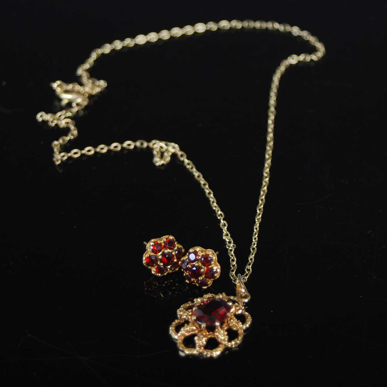 A 9ct gold and garnet set pendant suspended on a gold-plated necklace, together with a pair of 9ct