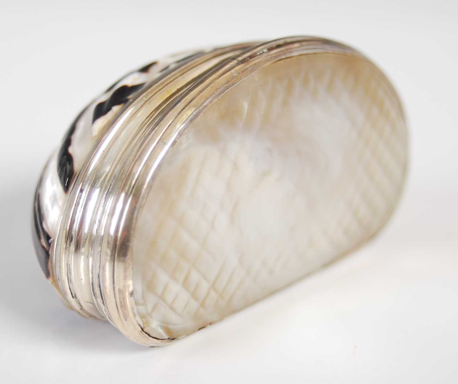 A Cittarium Pica ‘magpie’ shell snuff box, carved to produce a decorative design, with reeded silver - Image 2 of 3
